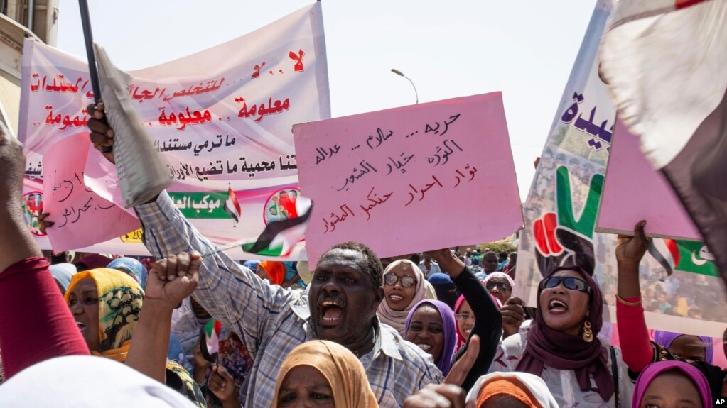 Les manifestants portent des affiches disant : "Liberté, justice et paix, et la révolution est le choix du peuple", Khartoum 2019