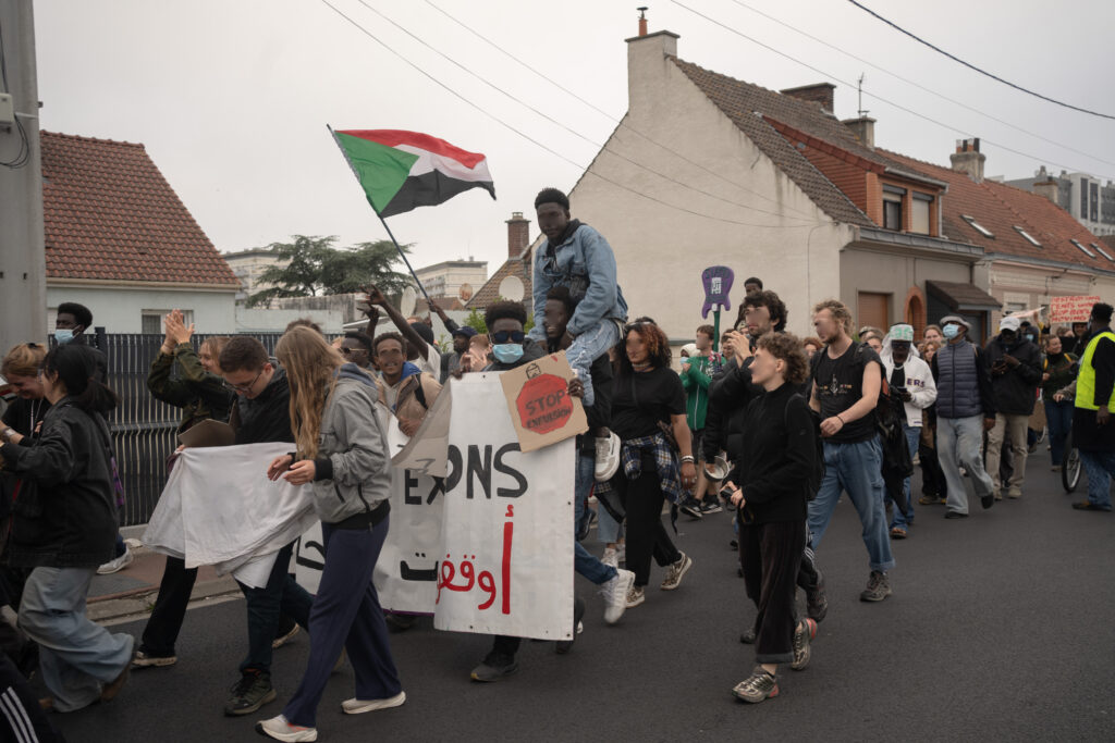 Manifestant·es à Calais avec un drapeau soudanais