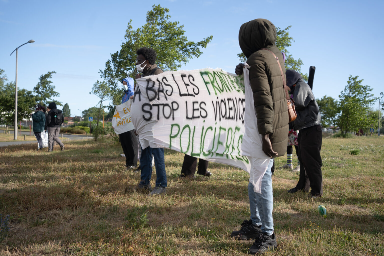 Manifestant·es à Calais avec une bannière : "A bas les frontières, stop les violences policières"